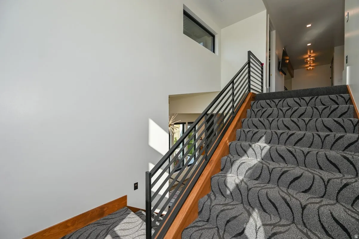 Carpeted staircase with a contemporary patterned runner and wood-finish risers