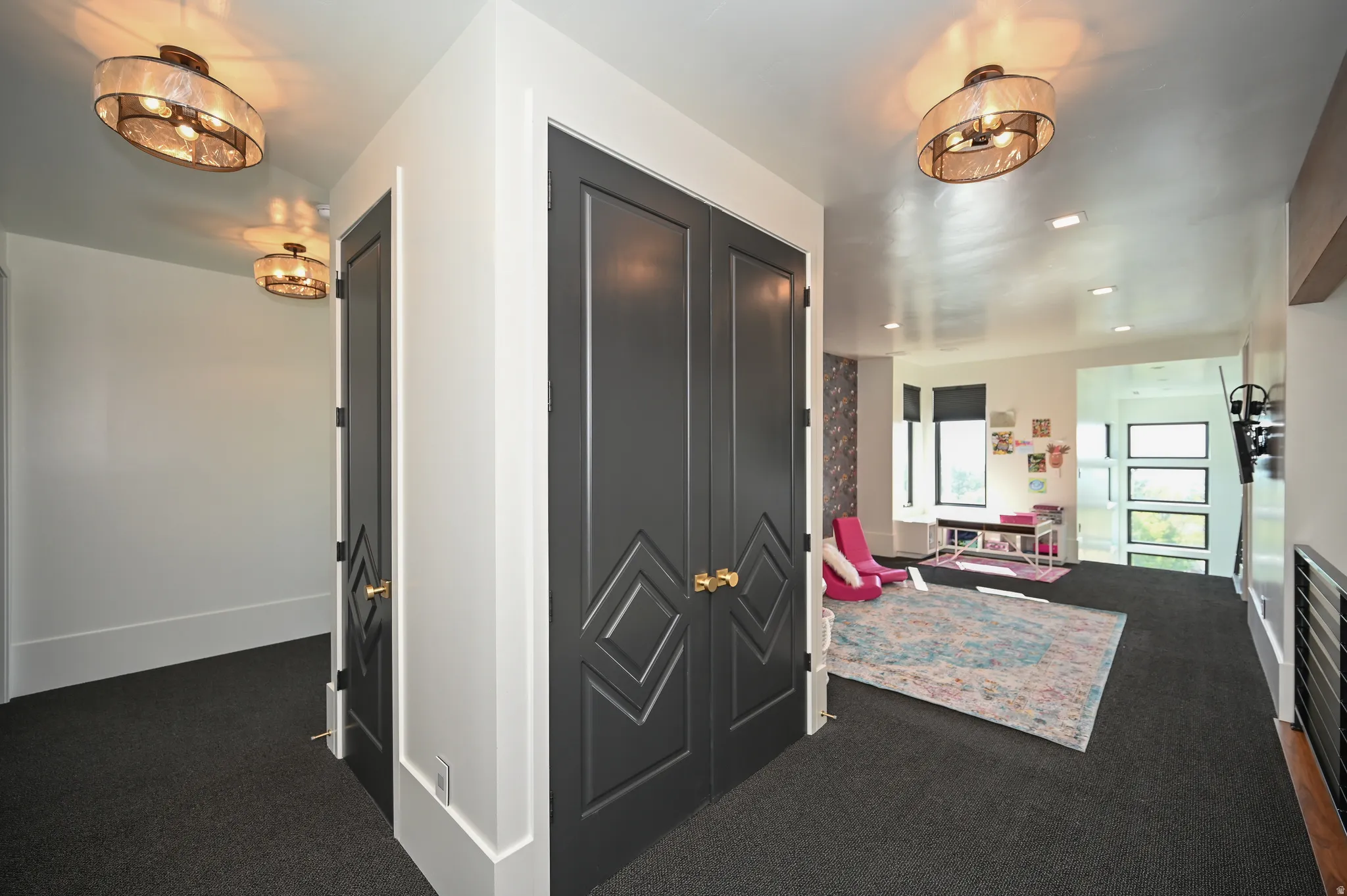 Hallway featuring dark gray doors with geometric detailing, dark gray carpeting, and recessed lighting