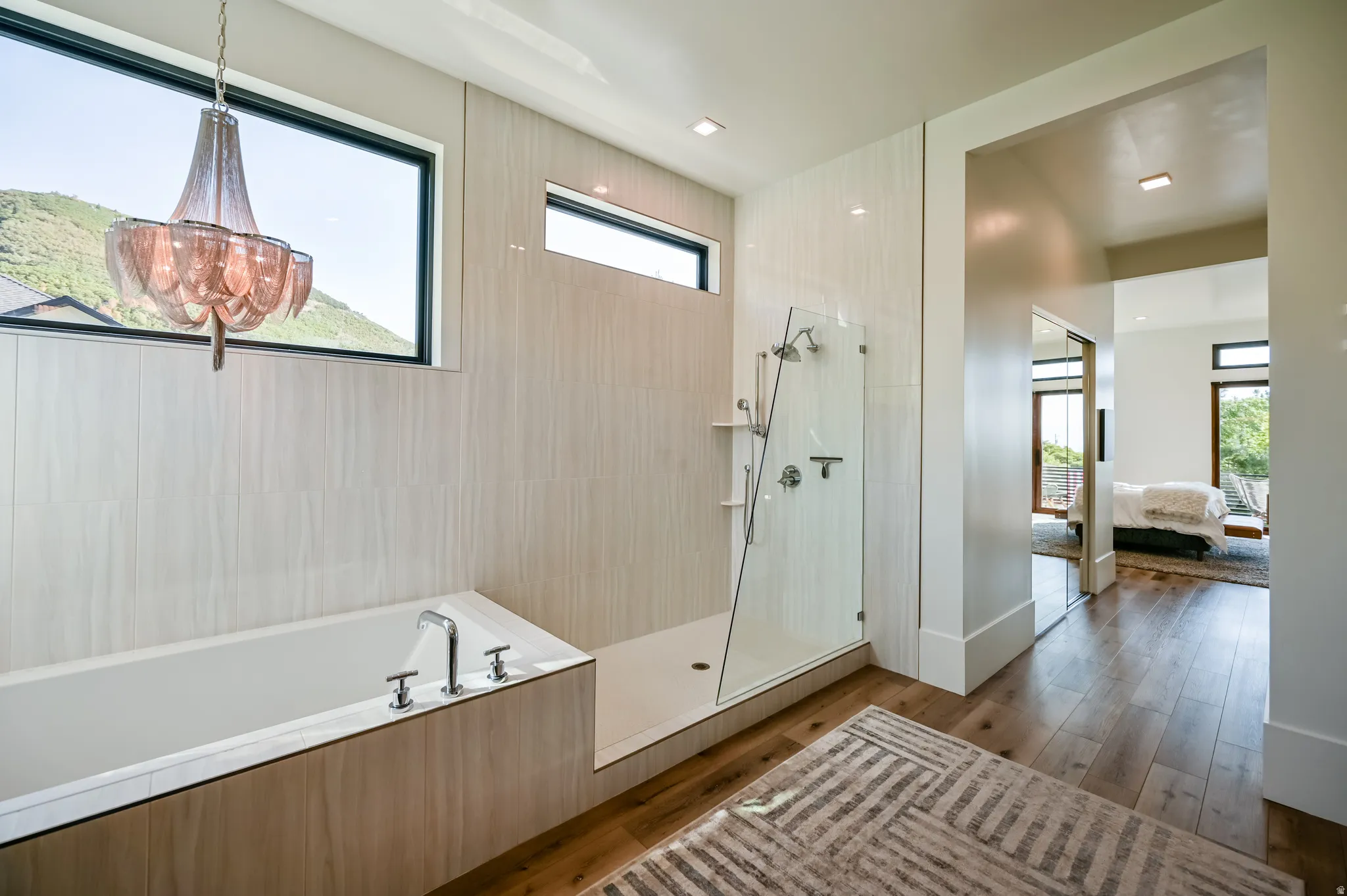 Contemporary bathroom featuring a large soaking tub with chrome fixtures and a glass-enclosed shower with multiple showerheads