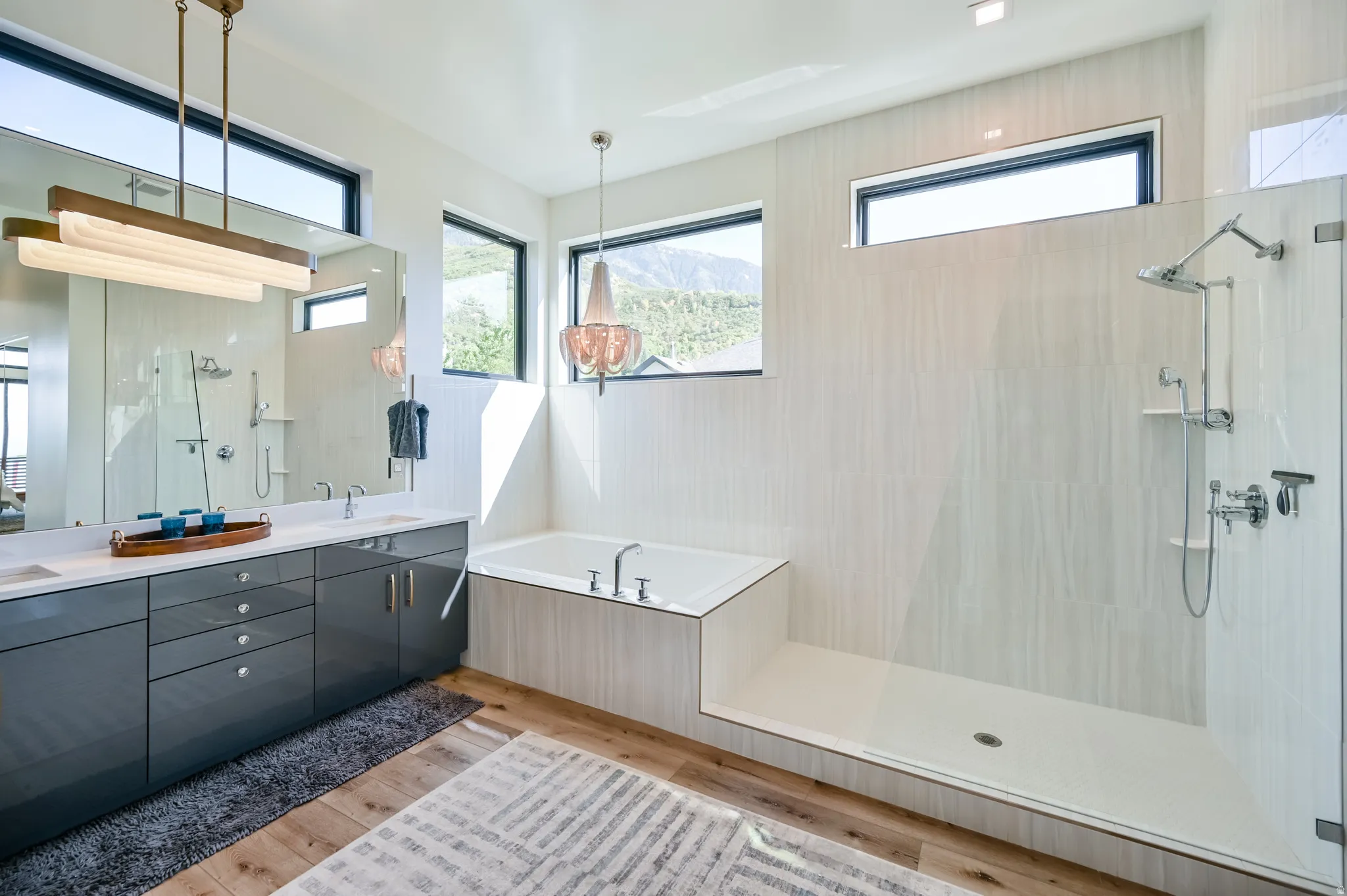 Contemporary bathroom featuring wood-finish flooring and a spacious walk-in shower with light-toned wall tiling