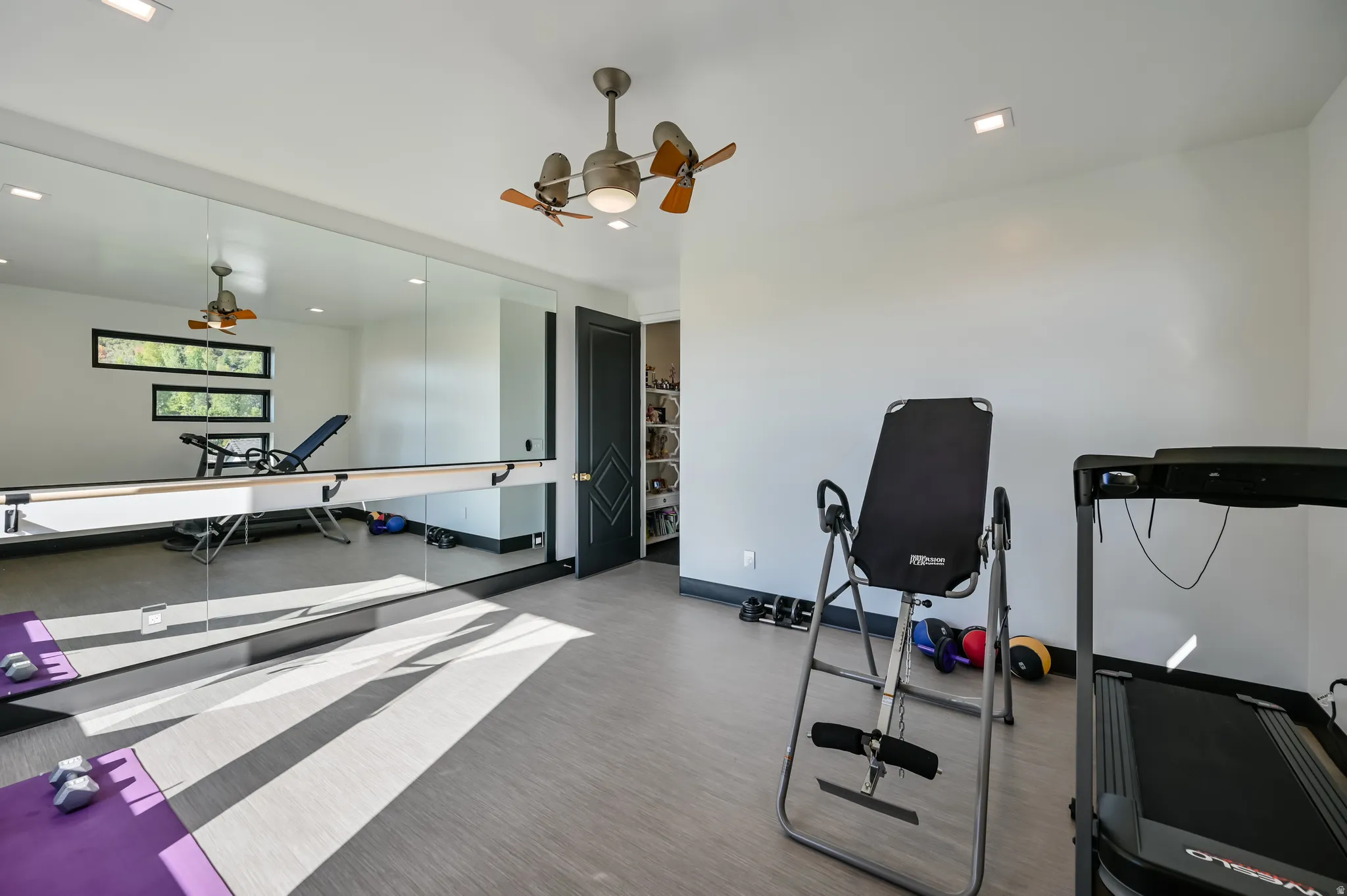 Dedicated fitness room featuring full-wall mirrors and a ballet barre