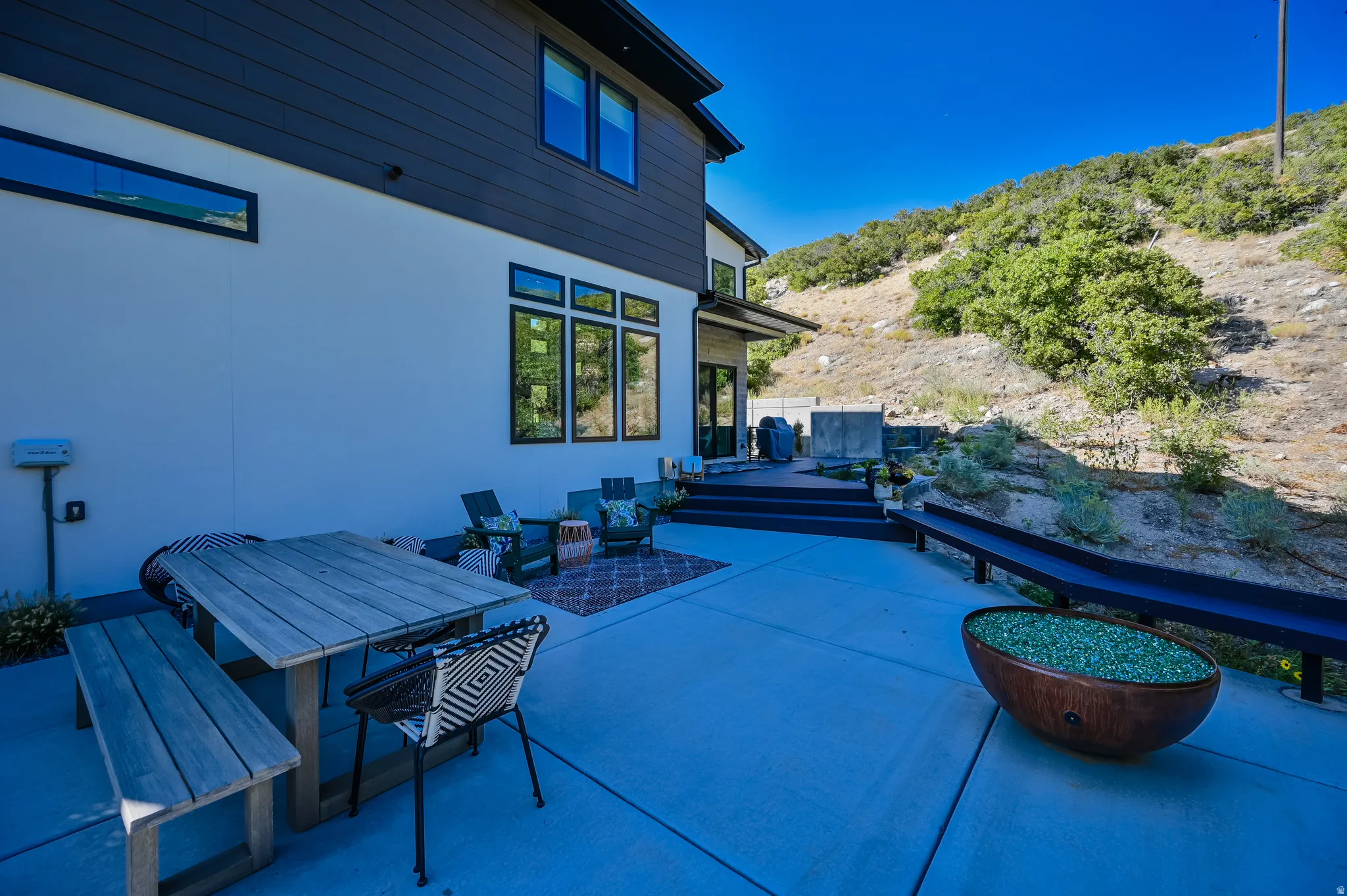 Expansive concrete patio with a modern fire pit feature