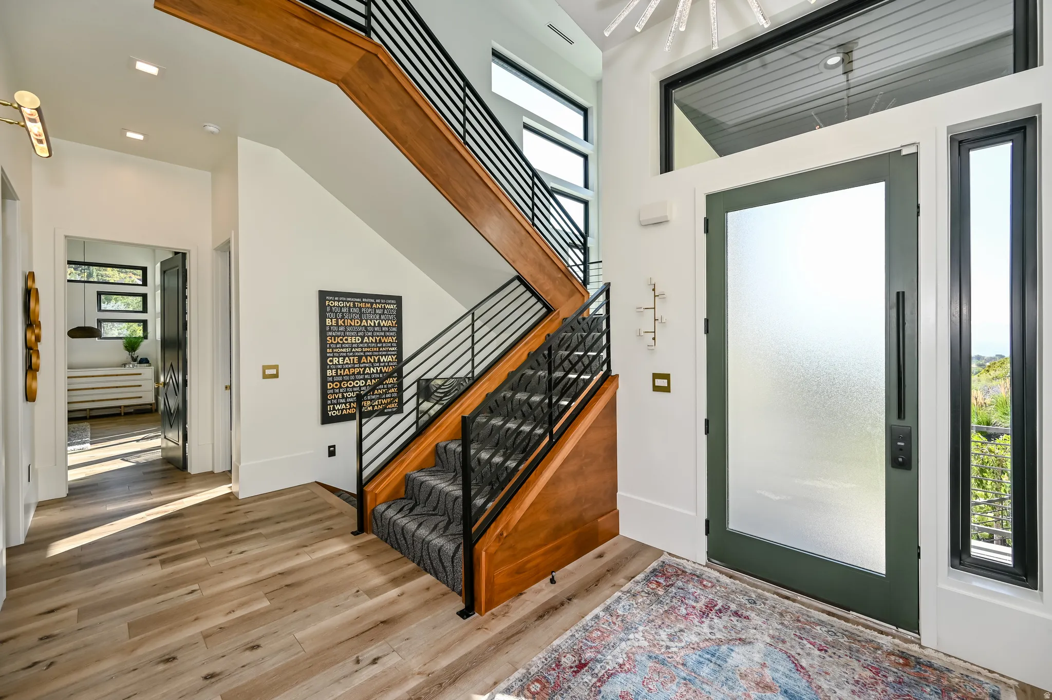 Modern entryway featuring a grand staircase with wood-finish treads and contemporary metal railings