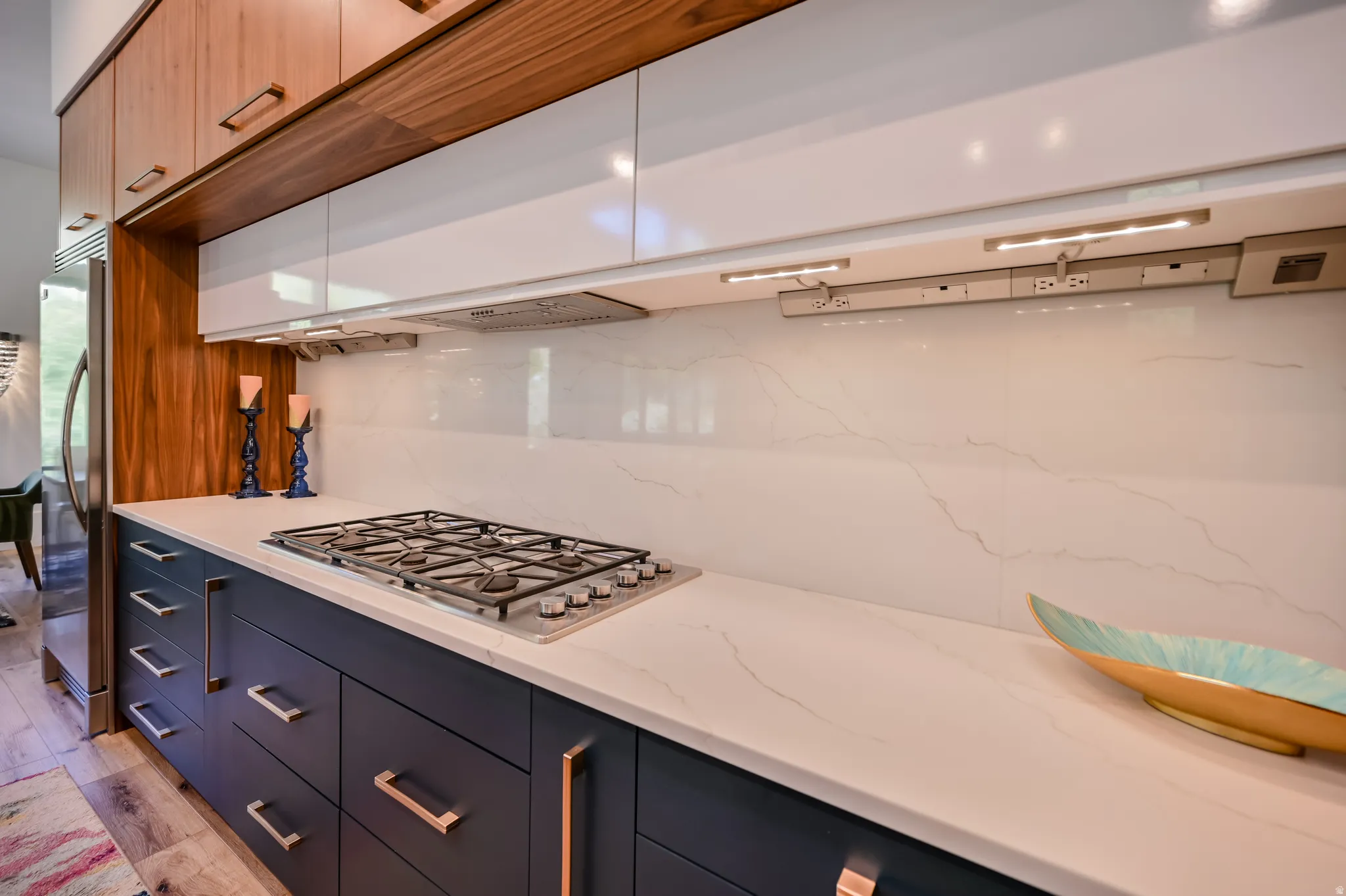 Sleek kitchen featuring a gas cooktop, light-toned countertop, and full-height backsplash