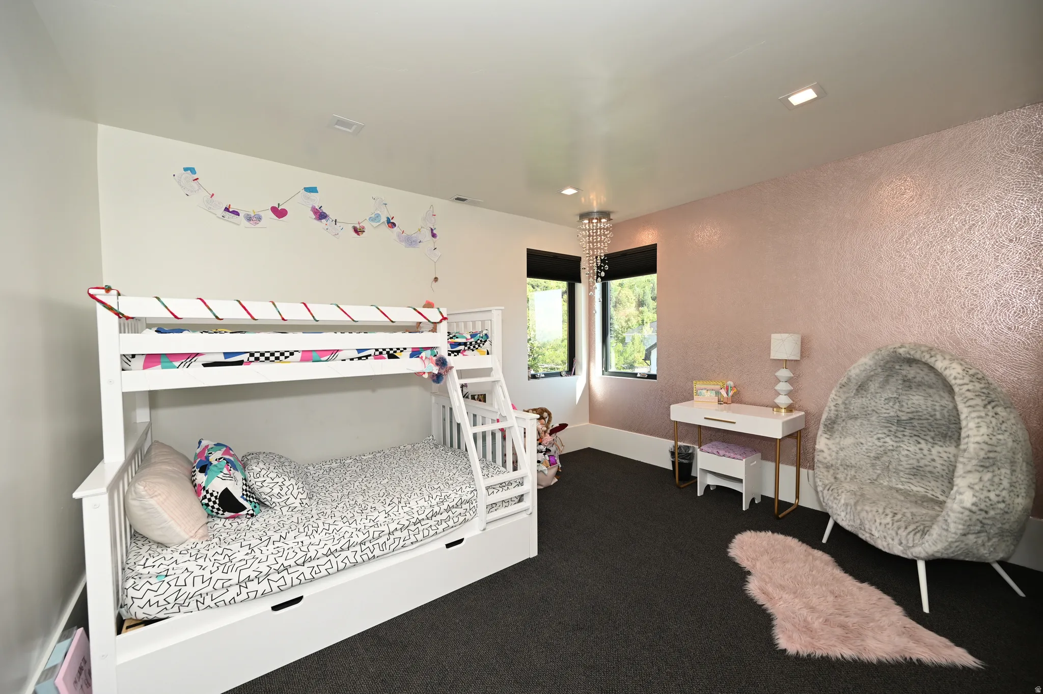 Room featuring dark carpeting, white baseboards, and a textured accent wall with a rose gold finish