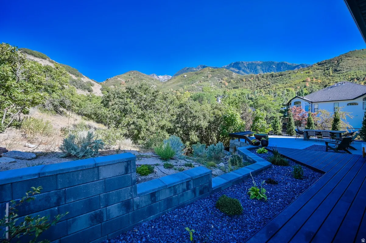 Expansive outdoor deck area featuring composite decking, a retaining wall, and a stone-filled garden bed