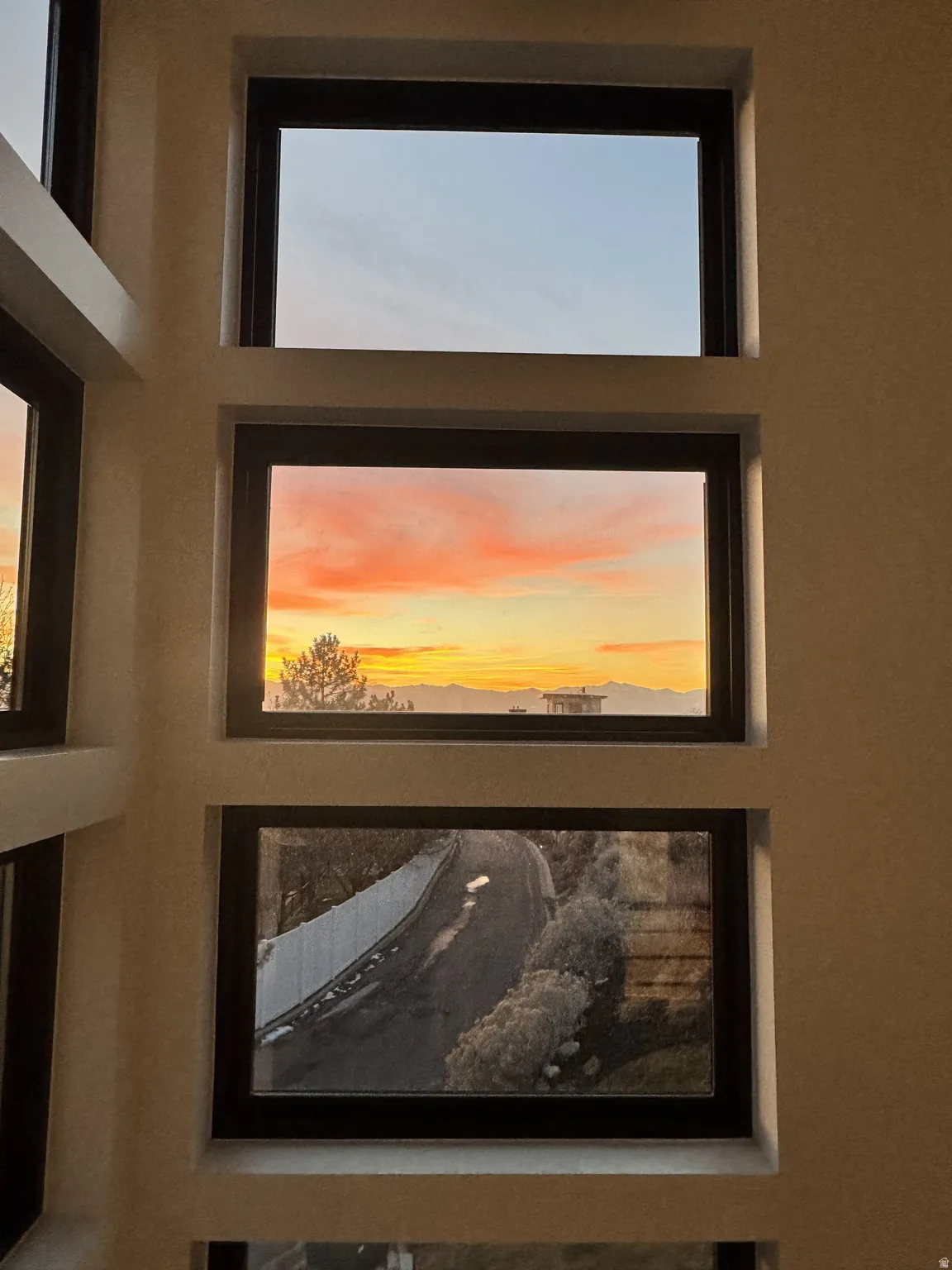 Expansive window array featuring dark frames and a textured wall finish