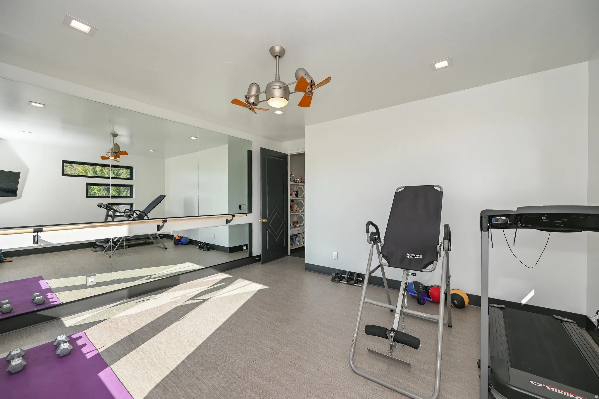 Dedicated fitness room featuring full-wall mirrors and a ballet barre