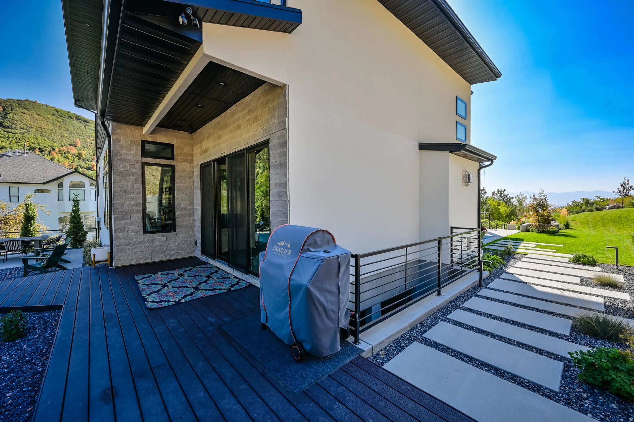 Expansive composite deck featuring a covered patio area and stone accent wall