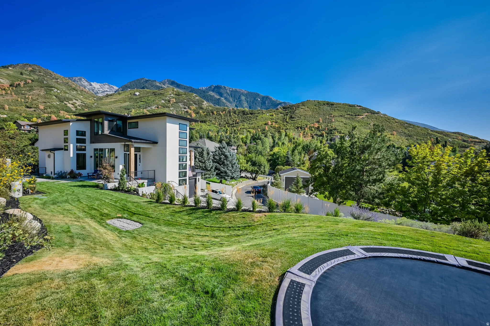 Modern residence featuring a light-toned exterior with dark trim accents and multiple large windows