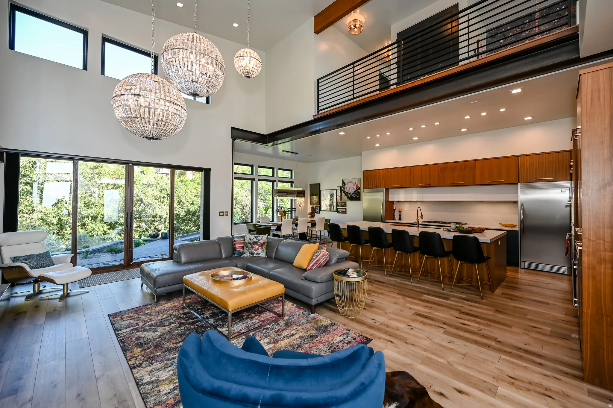 Double-height living area featuring wood-finish flooring and large sliding glass doors
