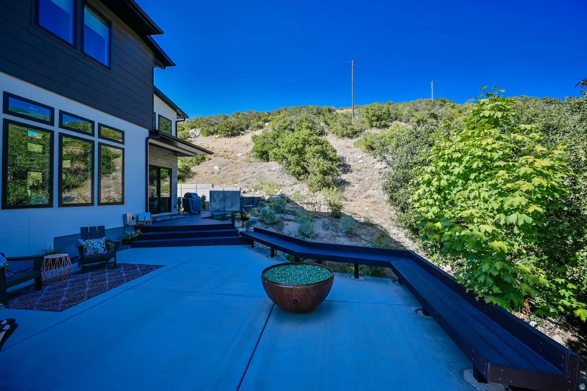 Expansive patio featuring a built-in bench and a decorative fire pit