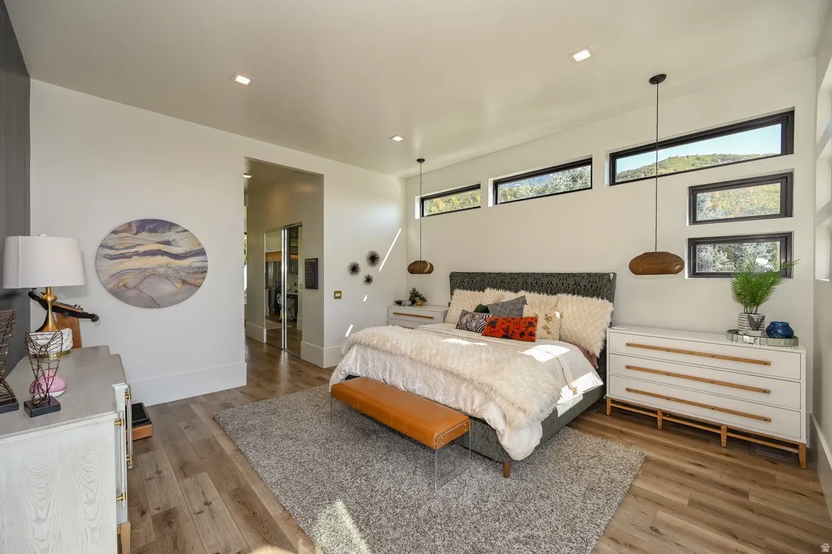Spacious interior featuring wood-finish flooring, recessed lighting, multiple transom windows, and a doorway opening to an additional area