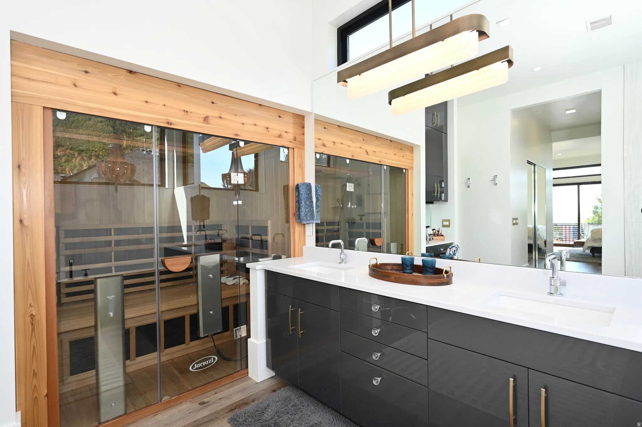 Dual vanity with quartz countertop, polished chrome fixtures, and dark gray cabinetry