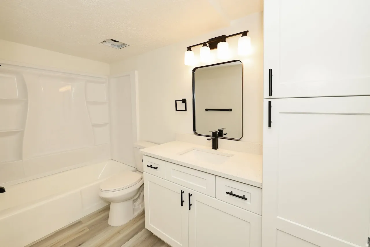Contemporary bathroom vanity featuring white cabinetry, a built-in sink, and a quartz countertop