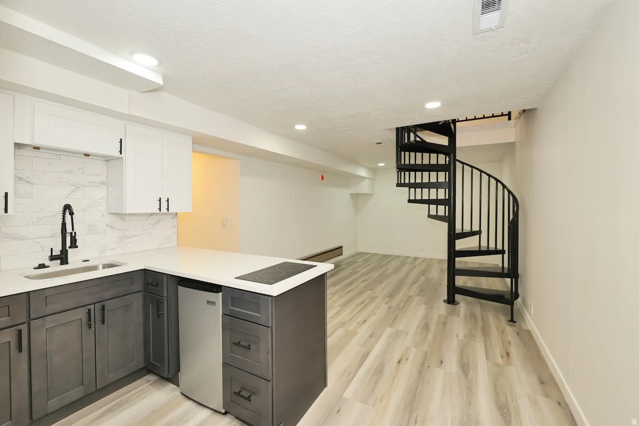 Open-concept living space with a contemporary kitchen area and spiral staircase