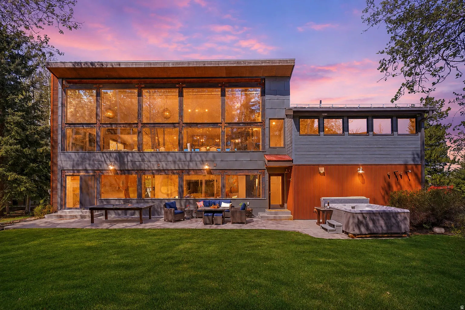 Modern architectural style featuring expansive multi-shttps://assets.utahrealestate.com/photos/280x210/2157117_faf30ade37d59e10b5b72911481288ca_6a0f38fe87f12.jpgtory window walls, a ground-level patio, and a built-in hot tub