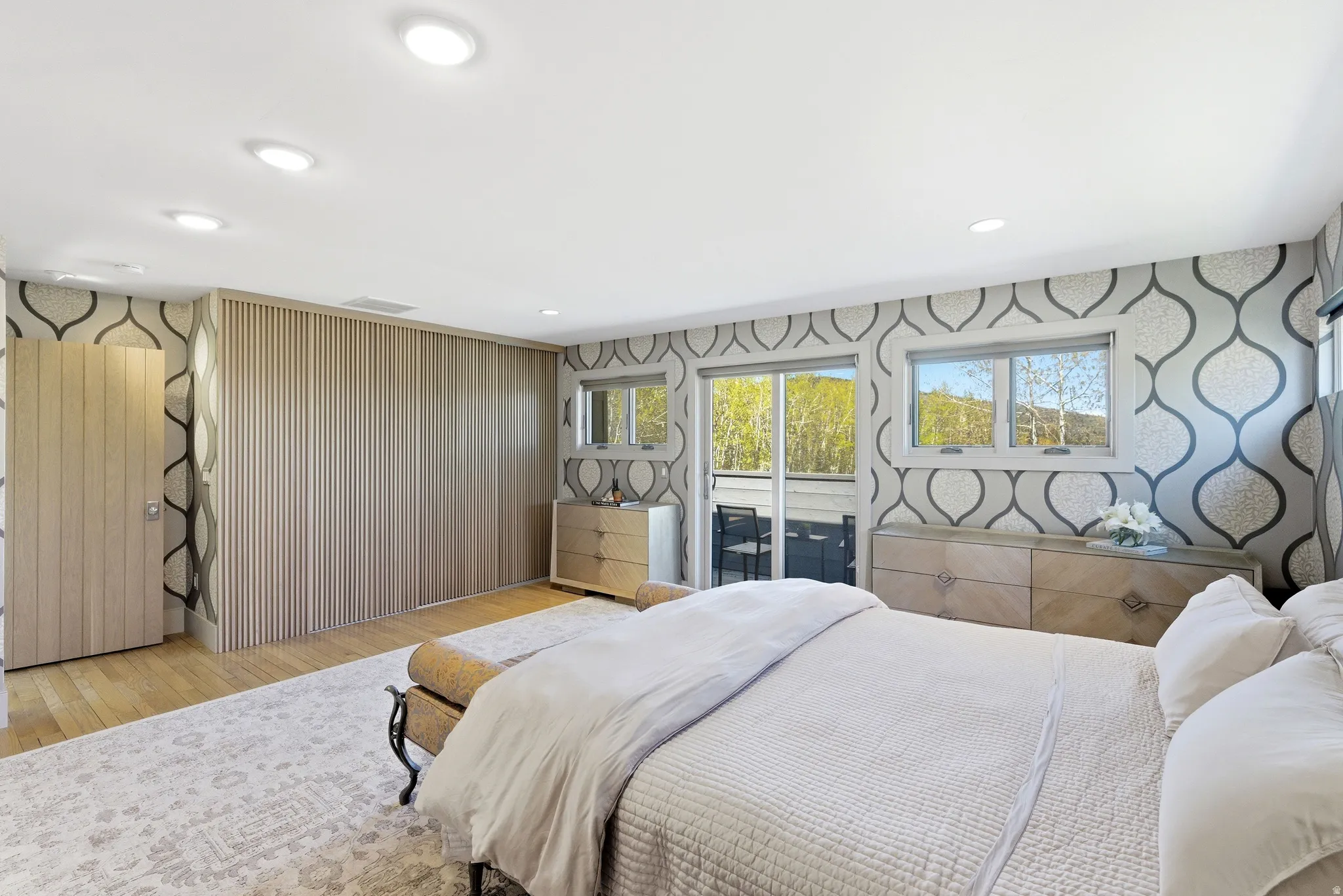Wood-finish flooring throughout this room featuring a full wall of integrated cabinetry