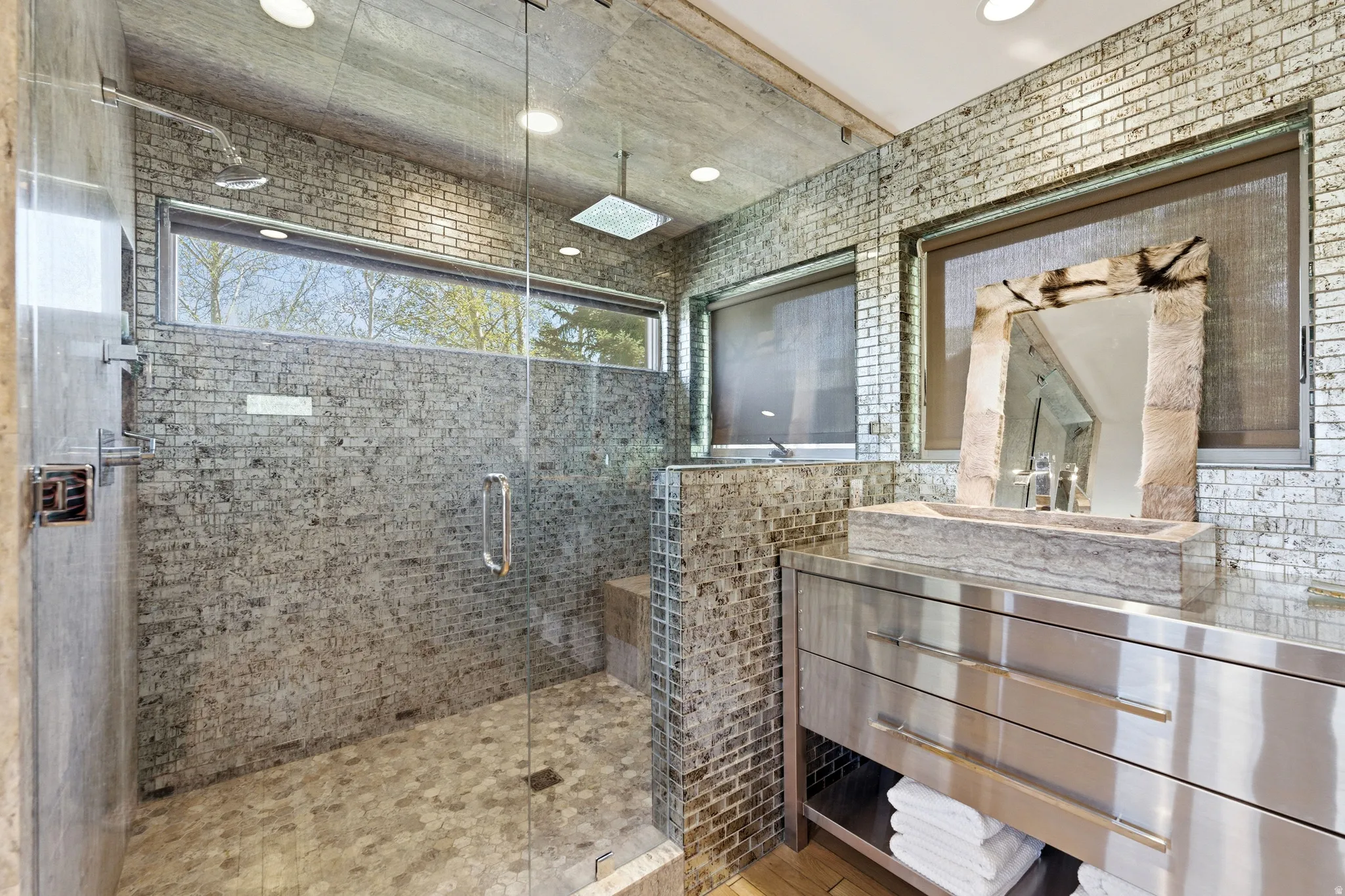 Contemporary bathroom featuring a walk-in shower with glass enclosure, mosaic tile walls, and a linear window