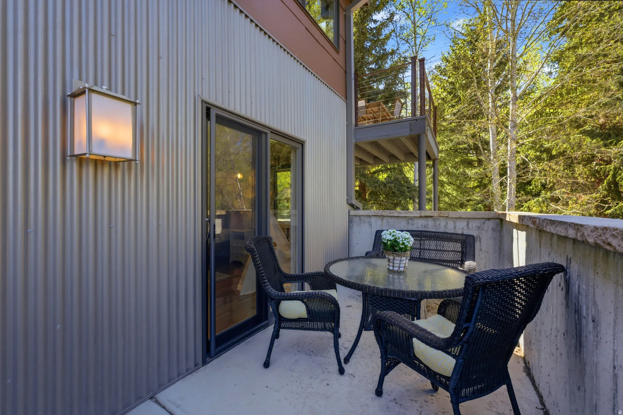 Private exterior patio featuring concrete flooring and a concrete retaining wall