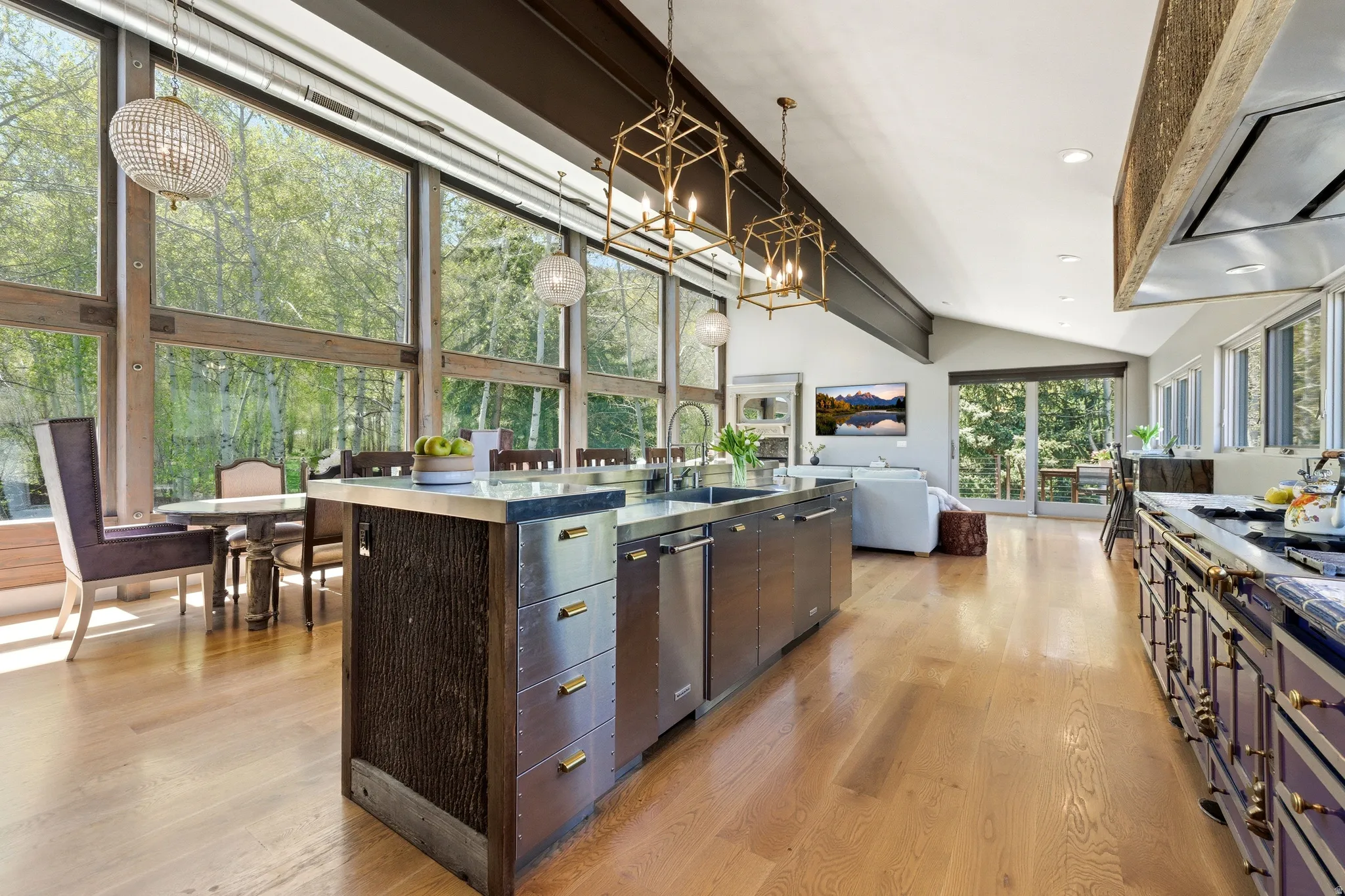 Expansive kitchen featuring a large island with integrated stainless steel appliances, a professional-grade range, and hardwood flooring