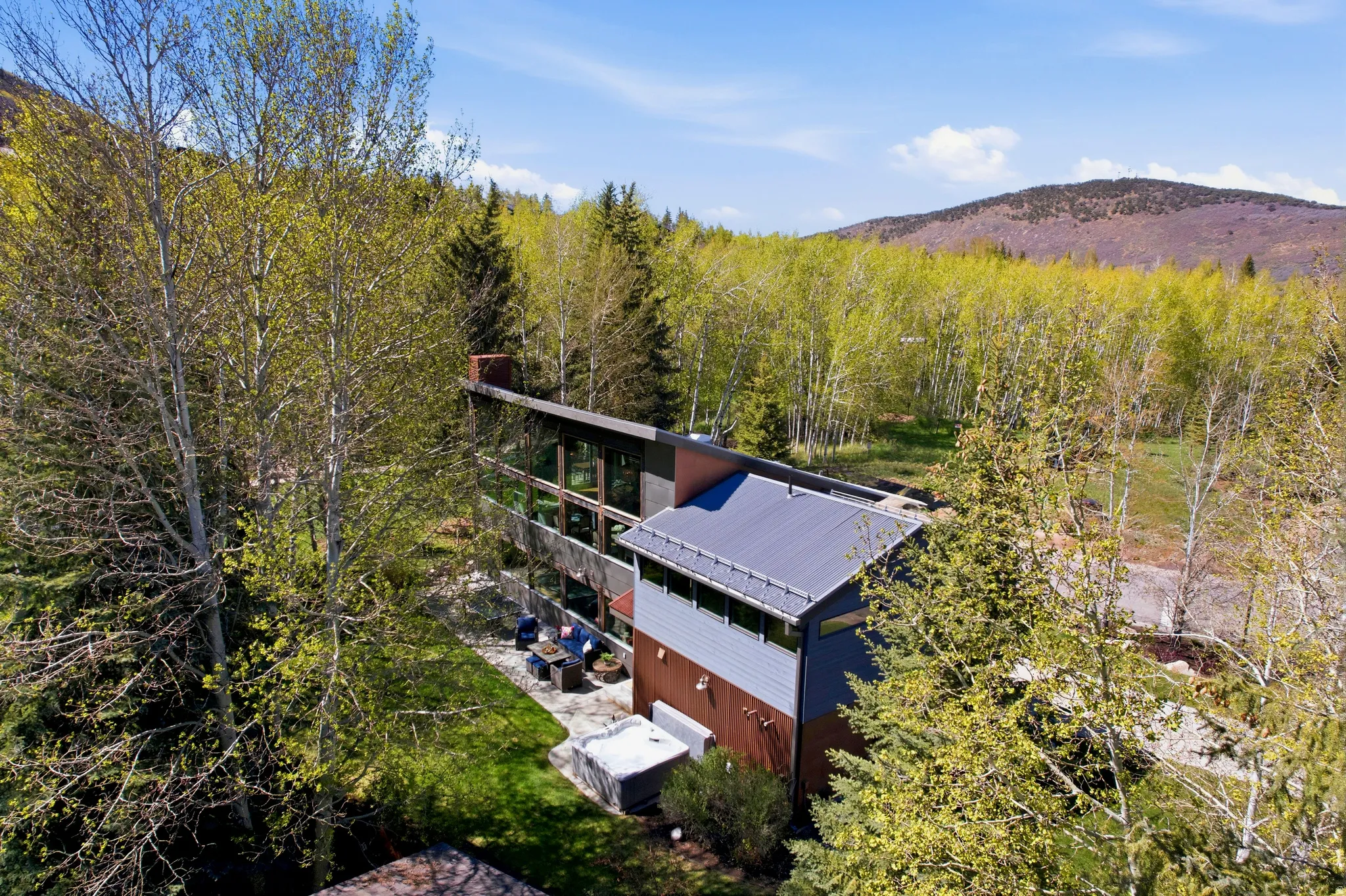 Contemporary architecture featuring a multi-level design, extensive glazing, and a metal roof