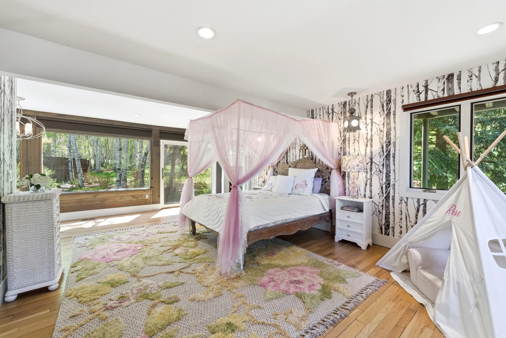 Spacious room featuring hardwood flooring, recessed lighting, and a large picture window with a sliding glass door