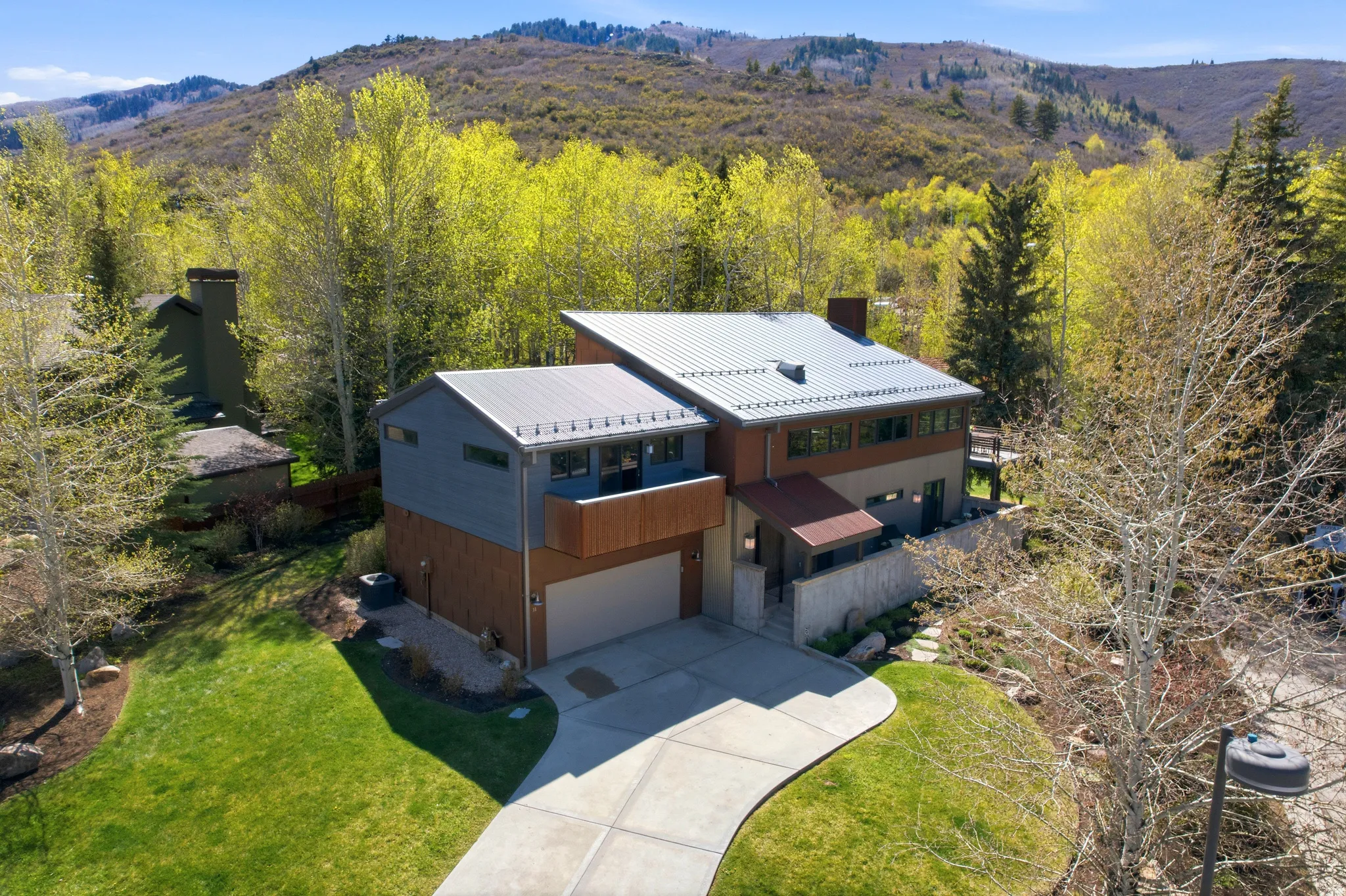 Contemporary architectural design featuring a metal roof, wood siding, and stone accents