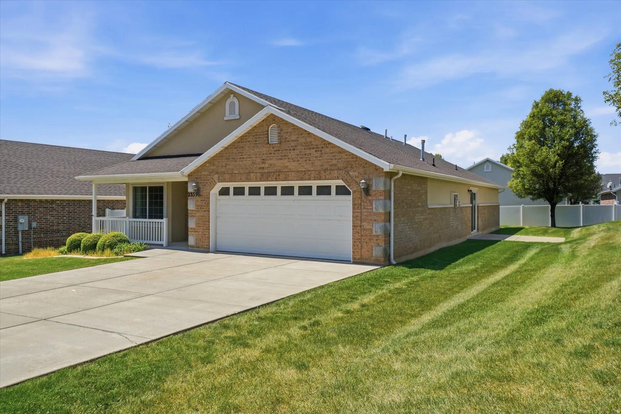 Brick and siding exterior featuring an integrated two-car garage with white panel door