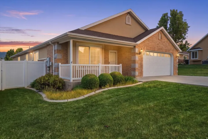 Brick and stucco exterior with an attached garage, white garage door, and concrete driveway