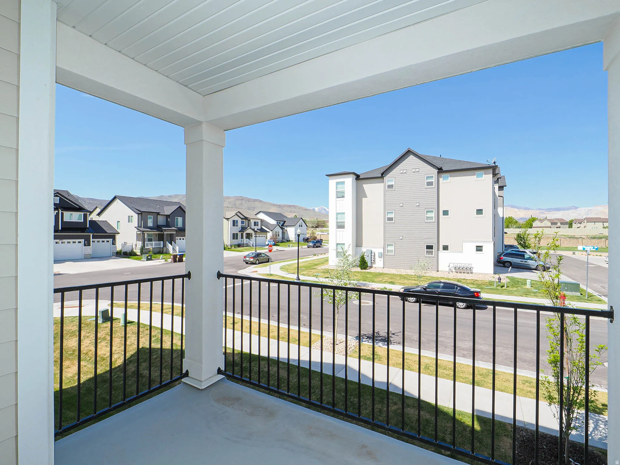 Covered balcony with white columns and black metal railing