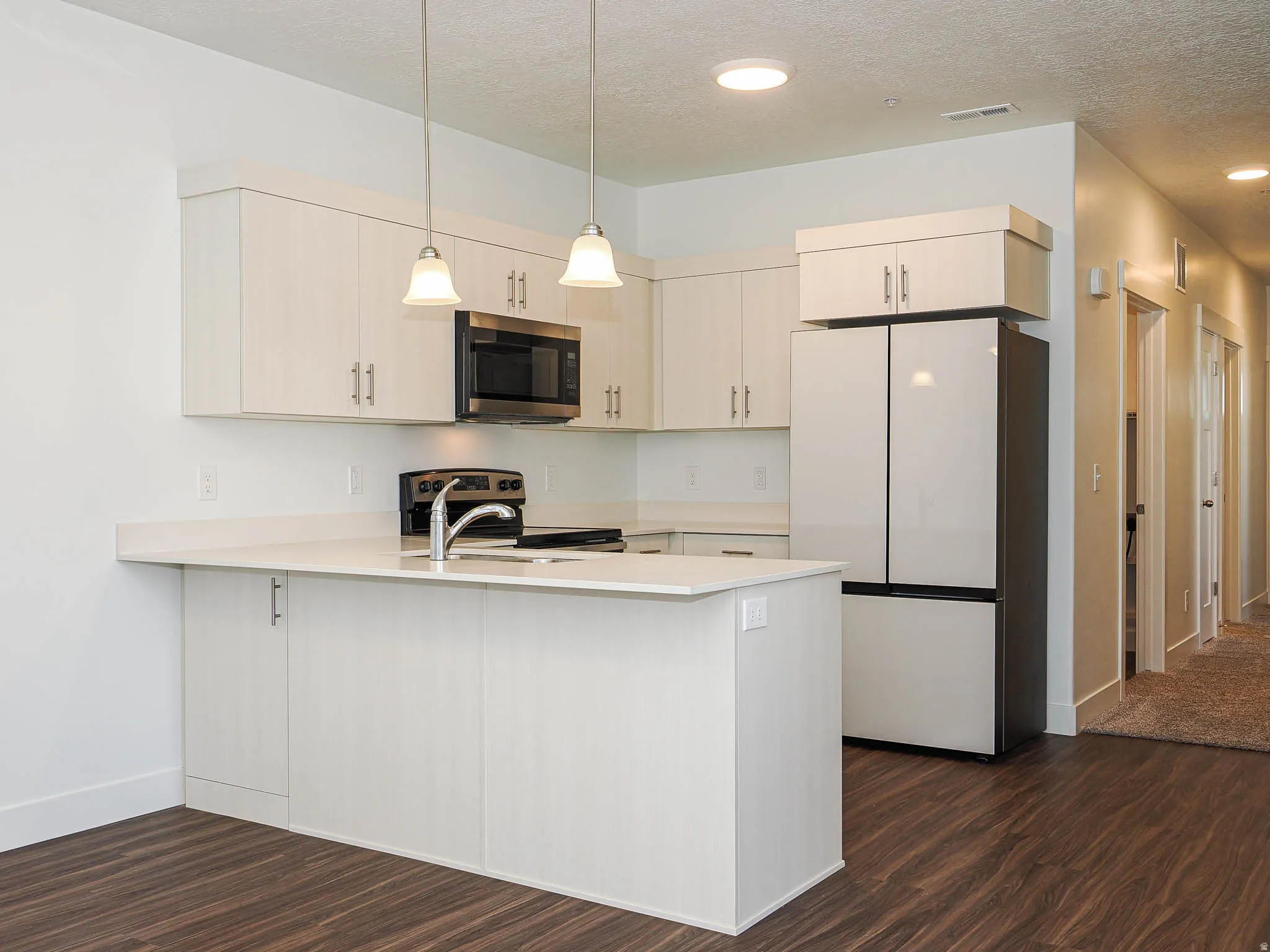 Modern kitchen with white cabinetry and light-toned countertops