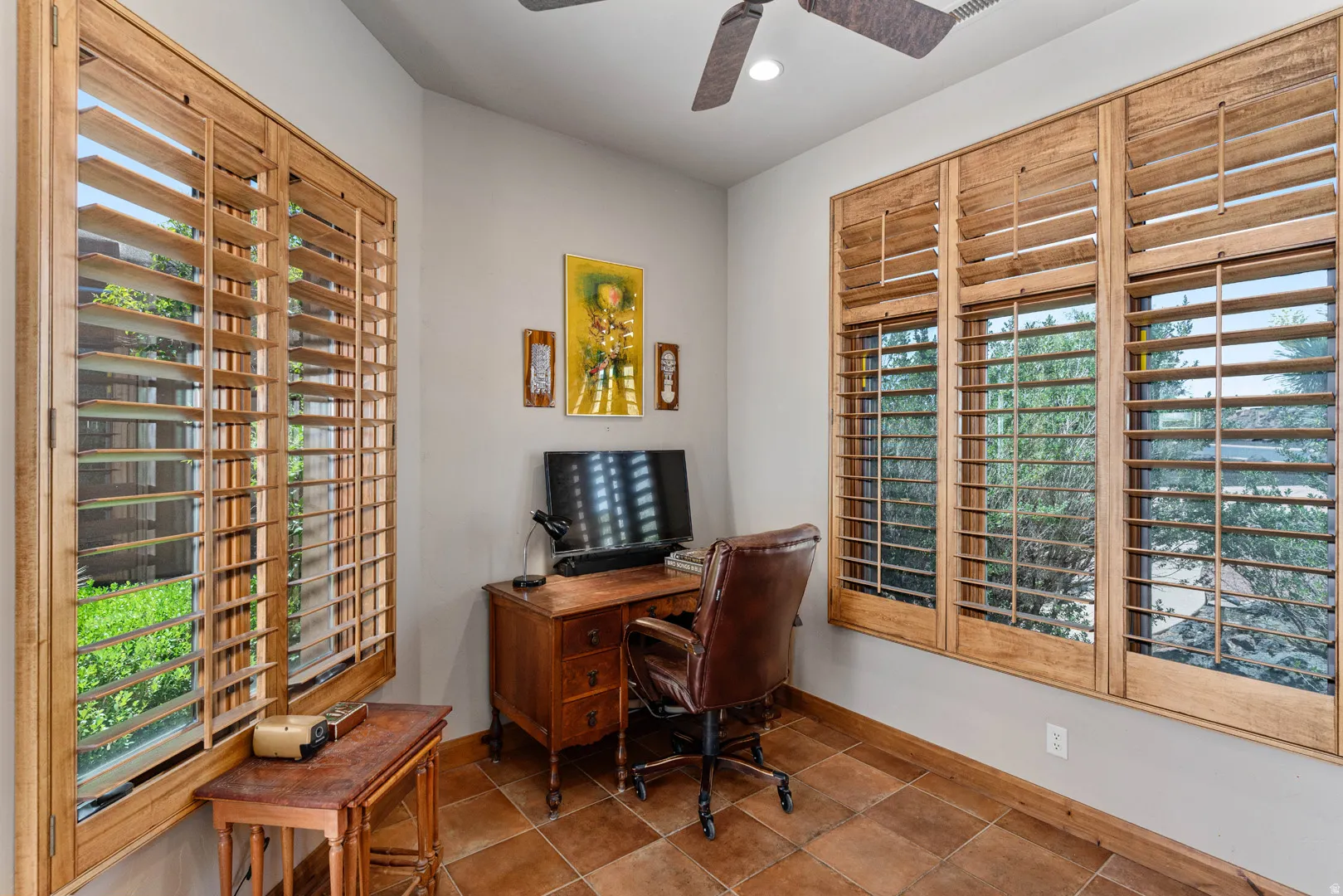 Room featuring multiple windows with wood plantation shutters, a ceiling fan, recessed lighting, and tile flooring