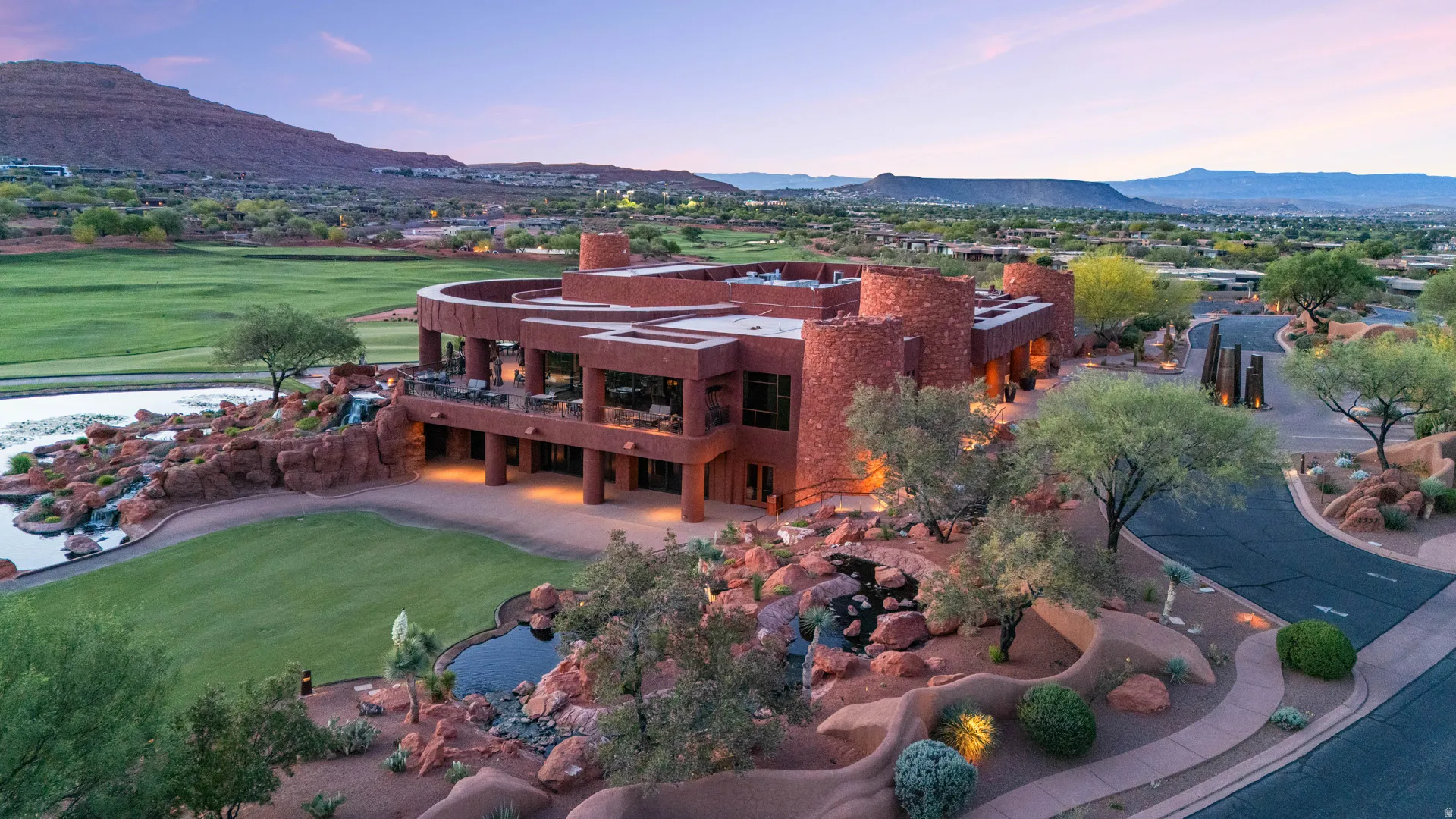 Southwestern-style building with multiple levels, featuring an expansive patio area with outdoor seating