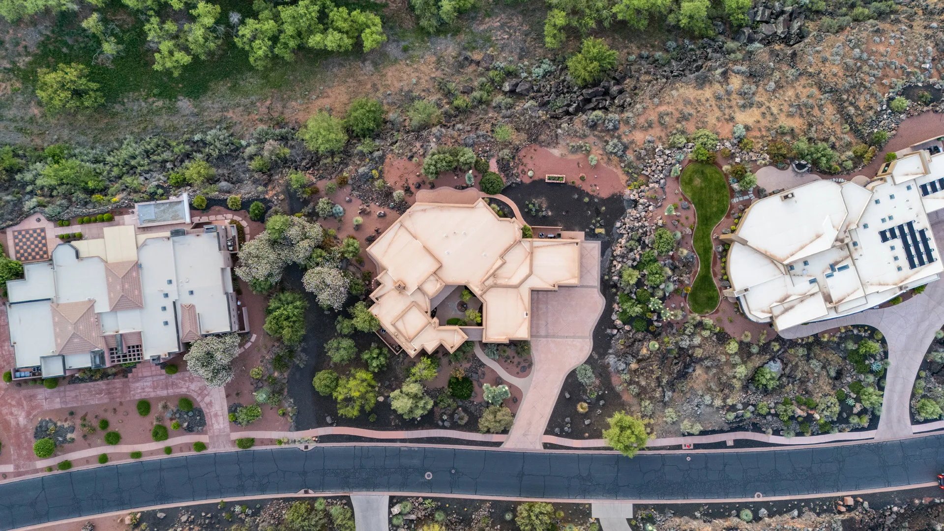 Aerial perspective showcasing a desert-landscaped property with a large, multi-level dwelling
