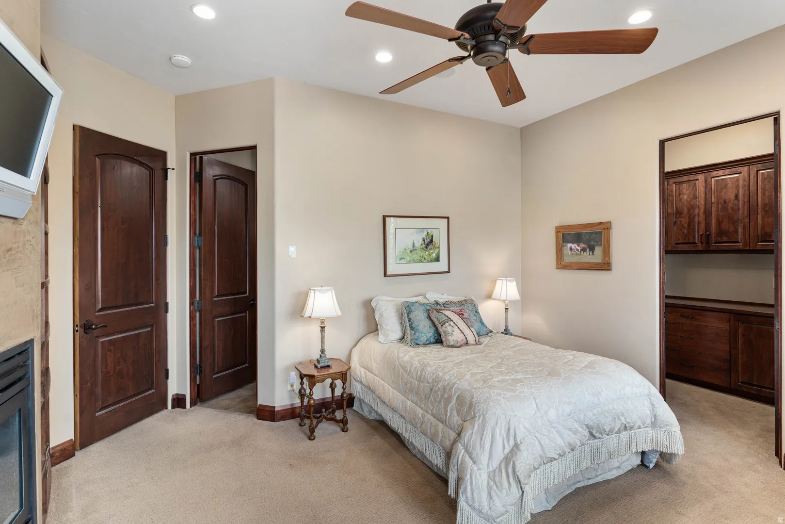 Carpeted room featuring a ceiling fan, recessed lighting, and a built-in wood-finish cabinet system