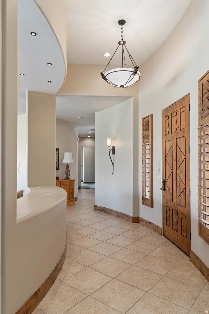 Entryway featuring diagonal tile flooring, a curved architectural wall, and a wood-panel door