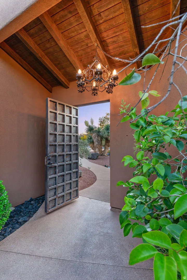 Entryway featuring a decorative wrought iron chandelier and a wood-beamed ceiling
