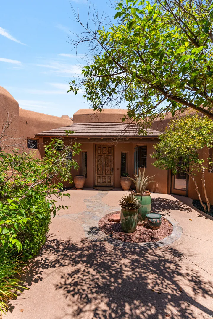 Southwestern-style exterior with a carved wood front door, covered entry, and a textured tile roof