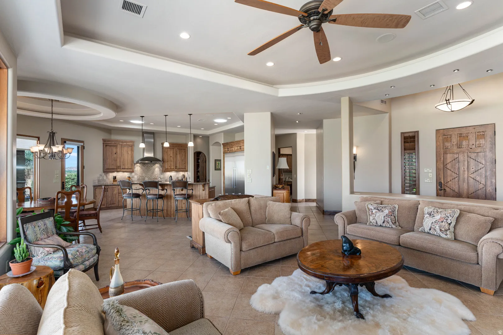 Open-concept living space with tile flooring, featuring a recessed ceiling, ceiling fan, and recessed lighting