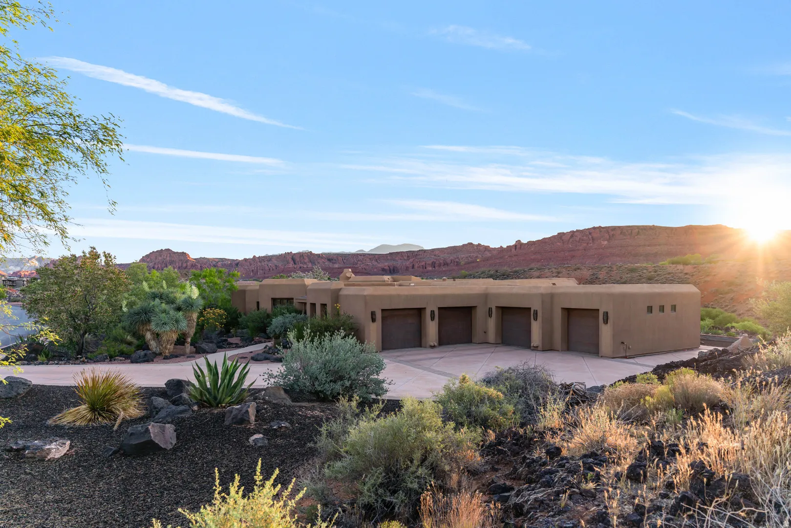 Southwestern-style residence featuring a stucco exterior and multiple garage doors