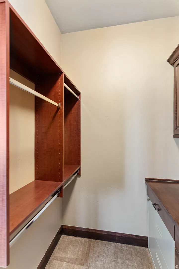 Custom closet system featuring rich wood-finish shelving and hanging rods