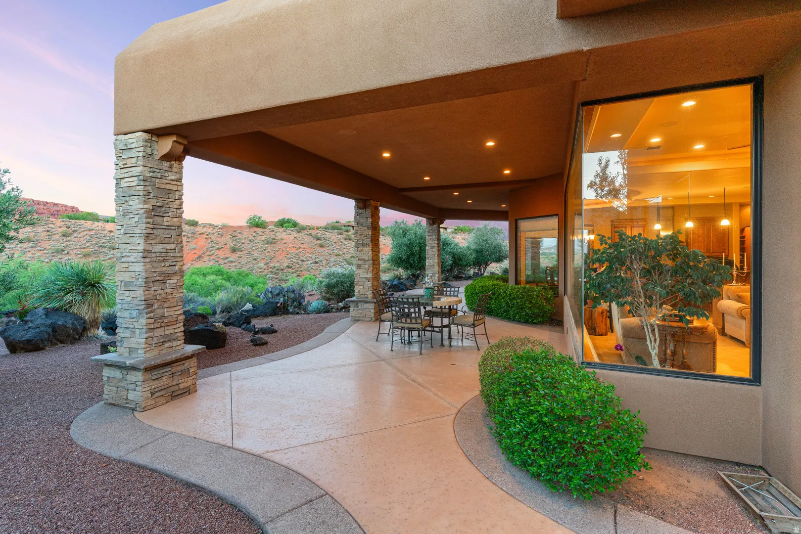Expansive covered patio with recessed lighting and stone-clad columns