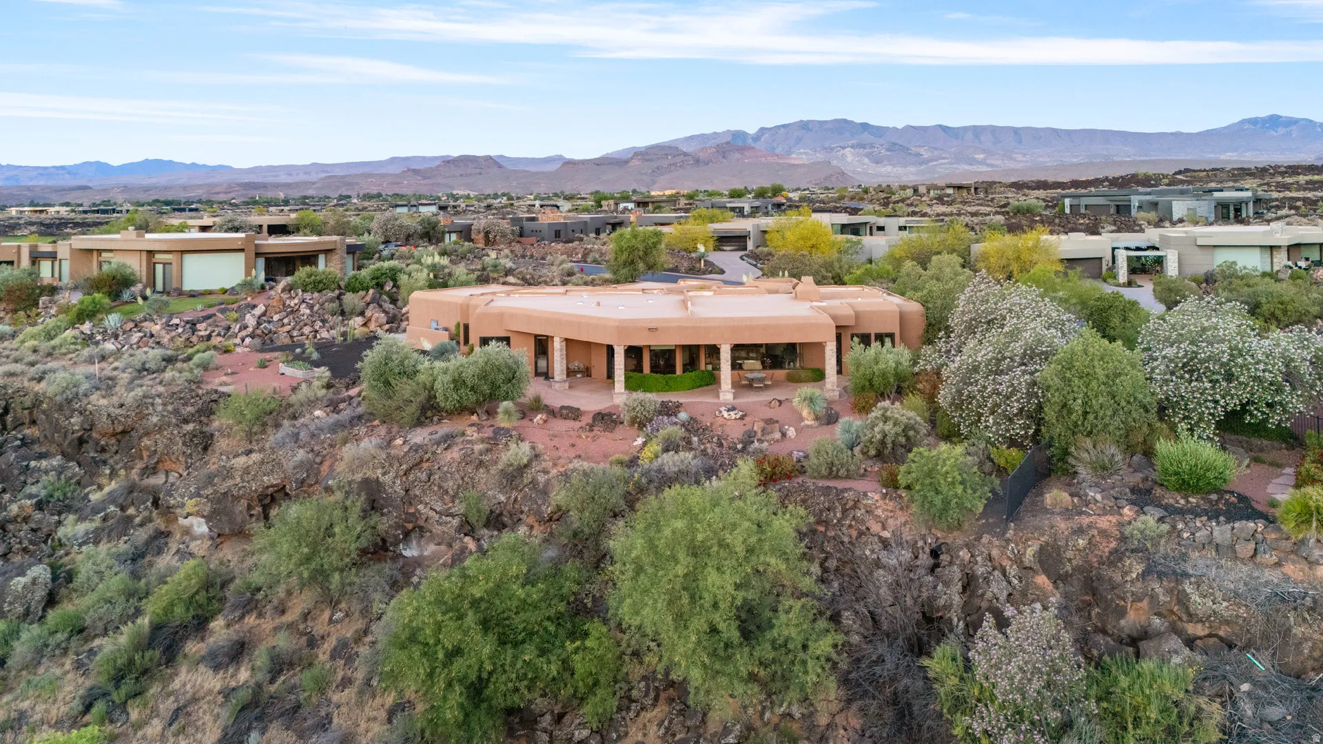 Desert-contemporary residence featuring a distinct architectural profile and a large covered patio