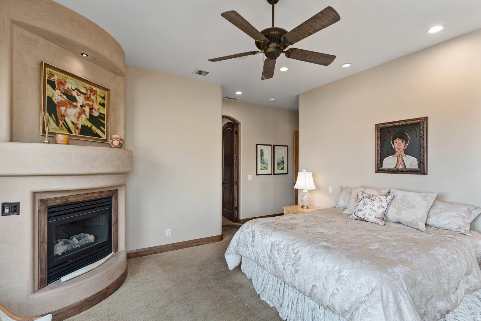 Primary bedroom featuring a corner fireplace with a wood-trimmed hearth, recessed ceiling lighting, a ceiling fan, and carpeted flooring