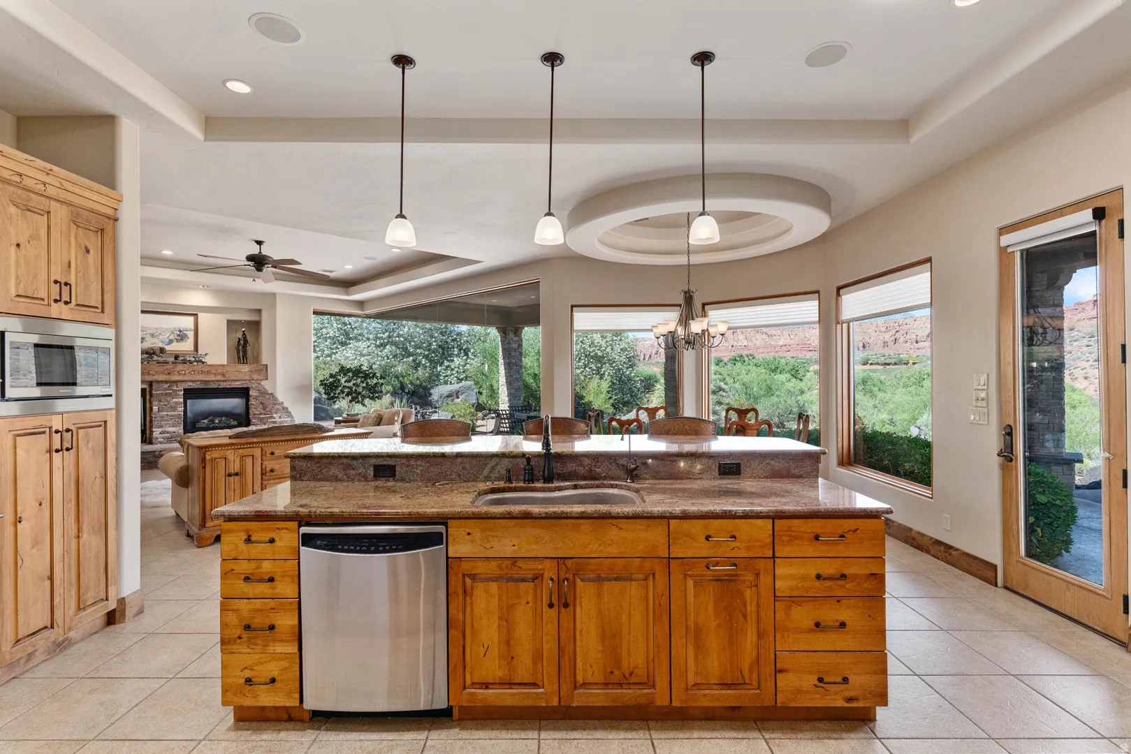 Kitchen island featuring granite countertops, undermount sink, and stainless steel dishwasher
