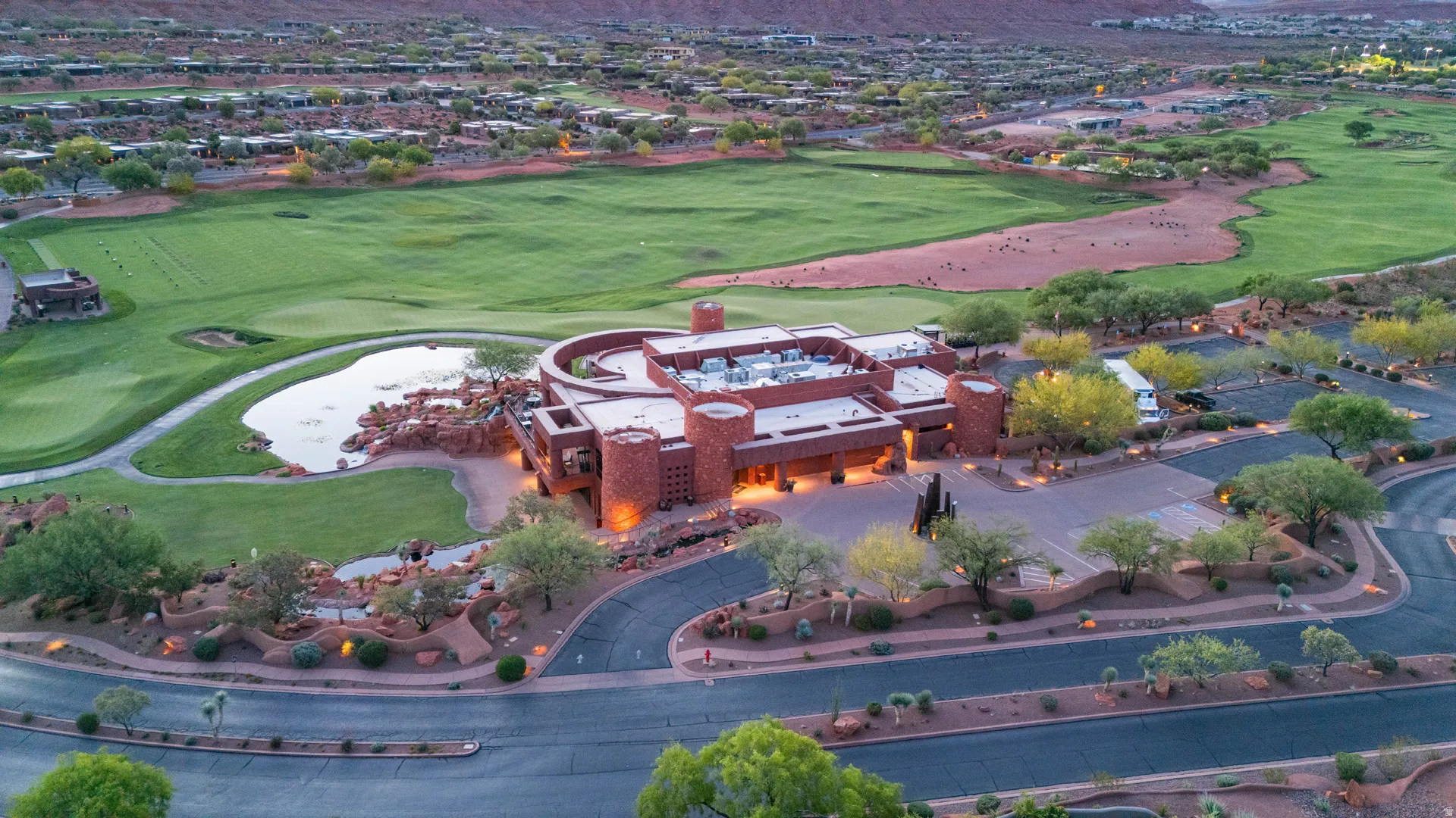 Clubhouse aerial perspective showcasing a red rock-inspired architectural structure with multiple turrets, surrounded by a manicured golf course