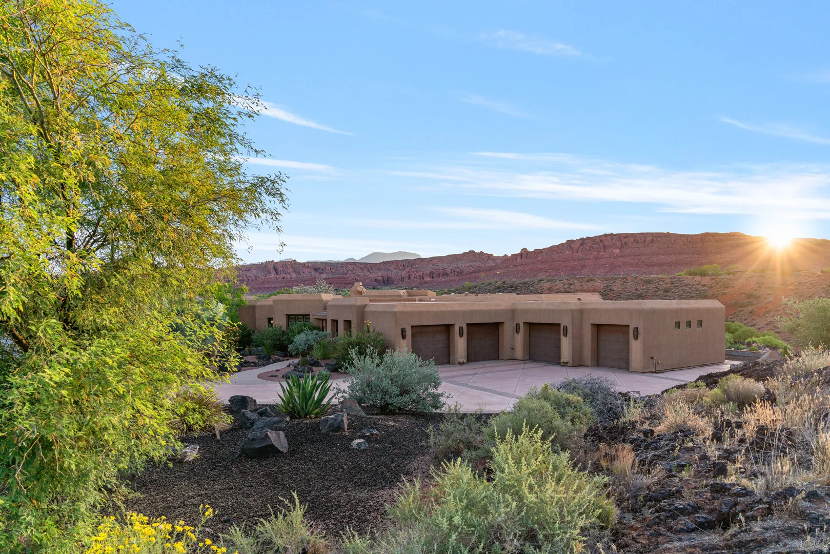 Southwestern-style residence featuring a stucco exterior and multiple garage bays
