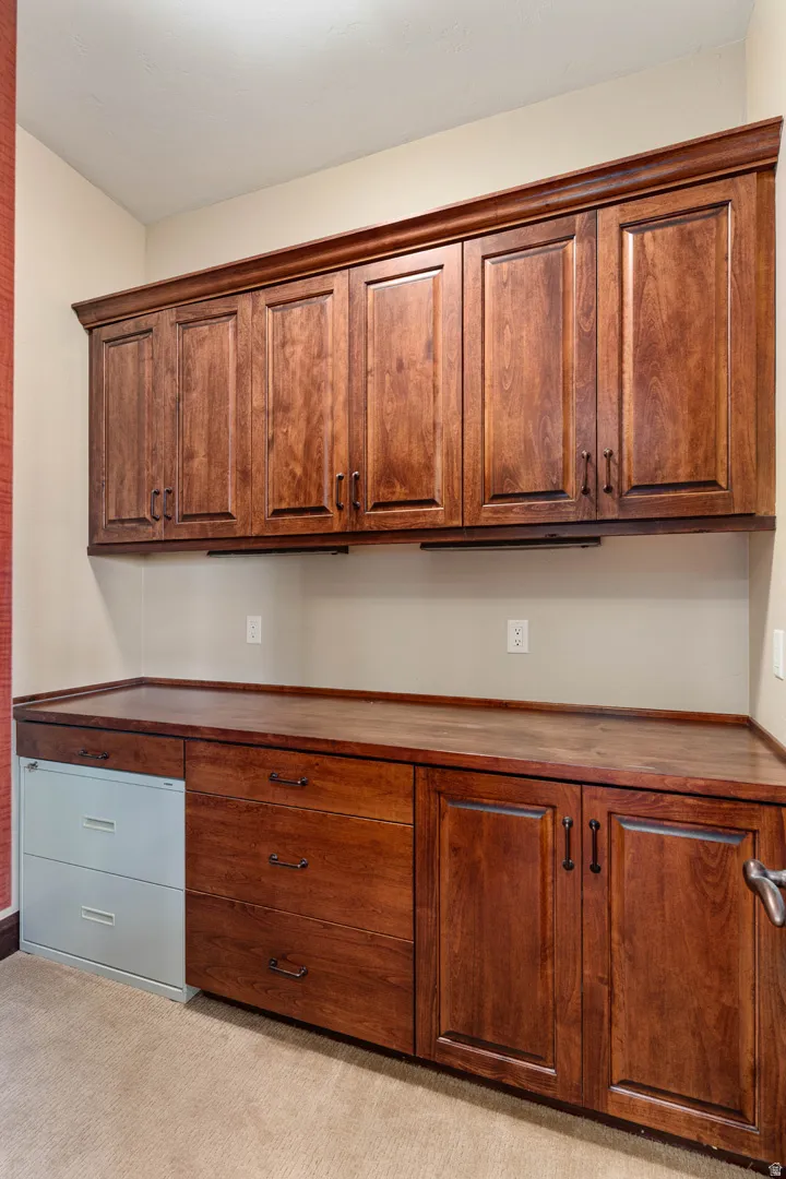 Built-in wood-finish cabinetry featuring overhead storage and a continuous wood-finish countertop