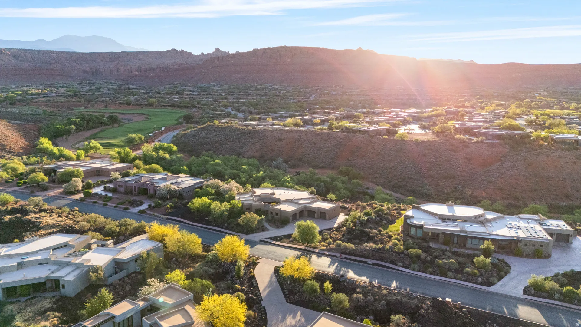 Modern residential properties set against a backdrop of natural rock formations and lush green landscaping